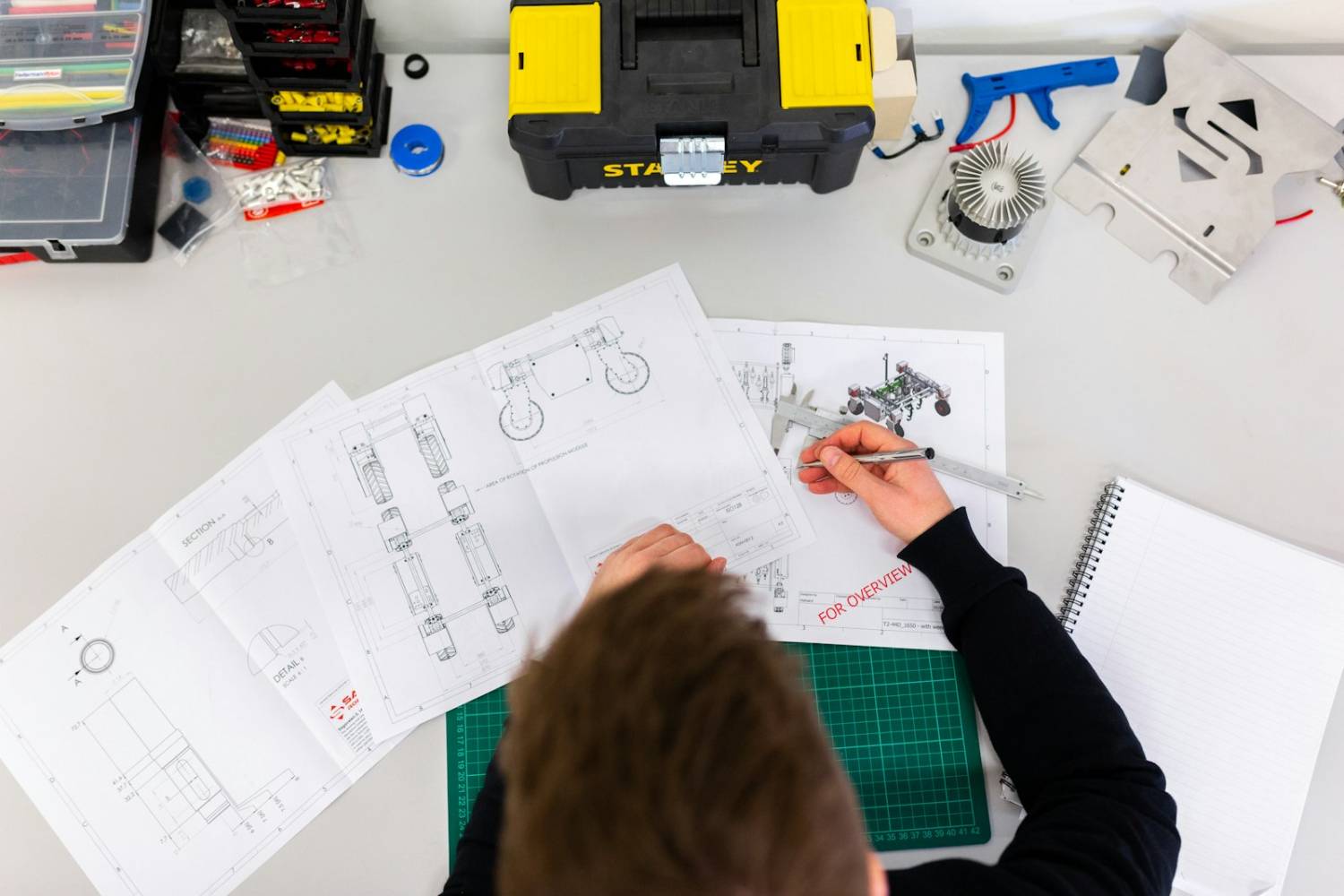 Engineer working over technical drawings at a workshop bench